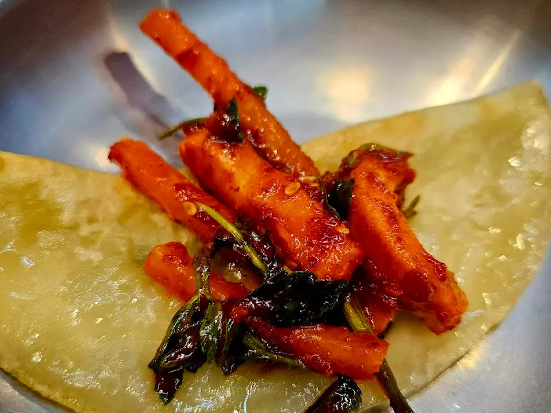 납작만두에 오징어 무침회를 올려 먹는 모습