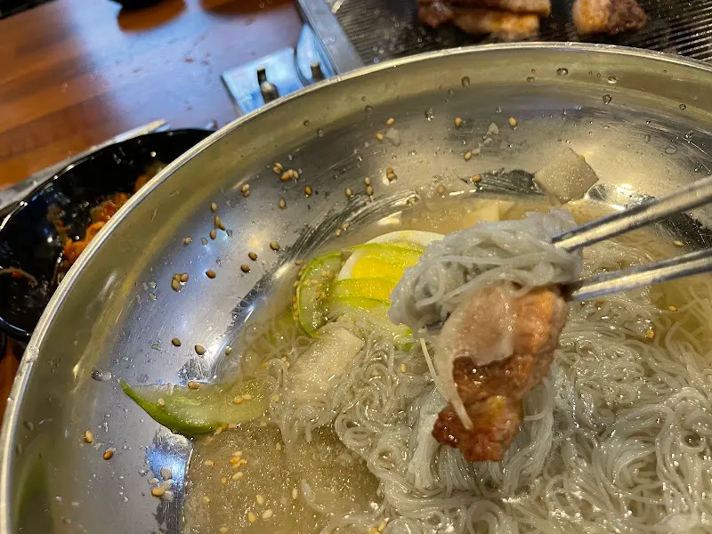 냉면에 고기를 올려 먹는 모습
