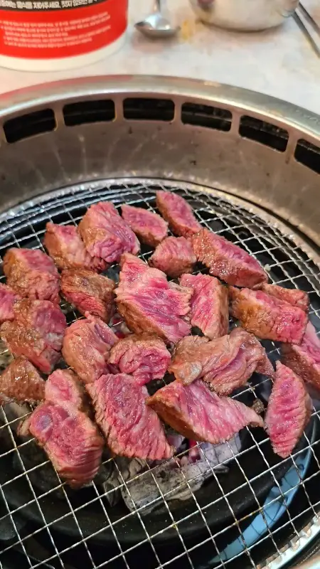 숯불 위에서 맛있게 익어가는 한우 조각들