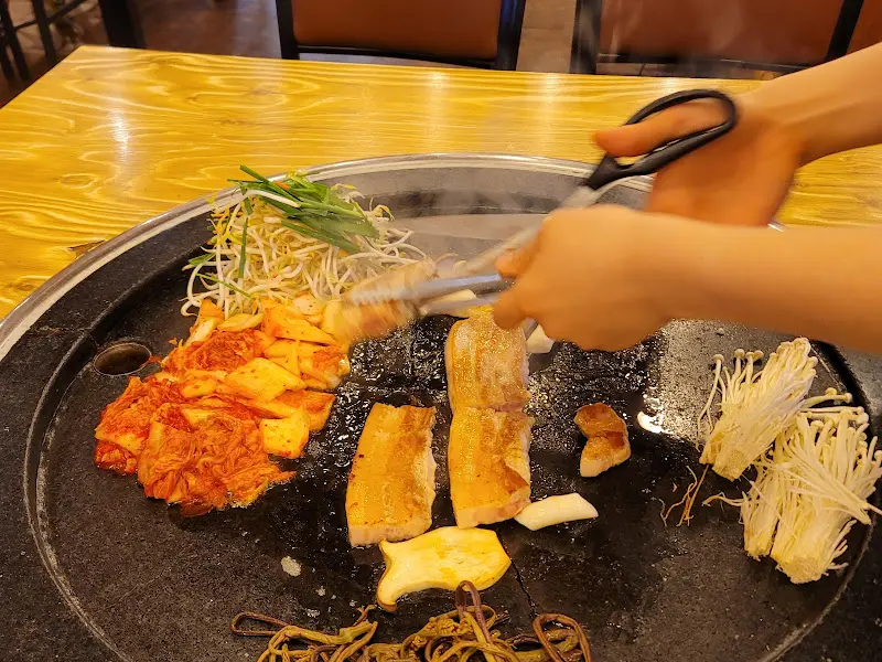 직원이 삼겹살을 자르고 있는 모습