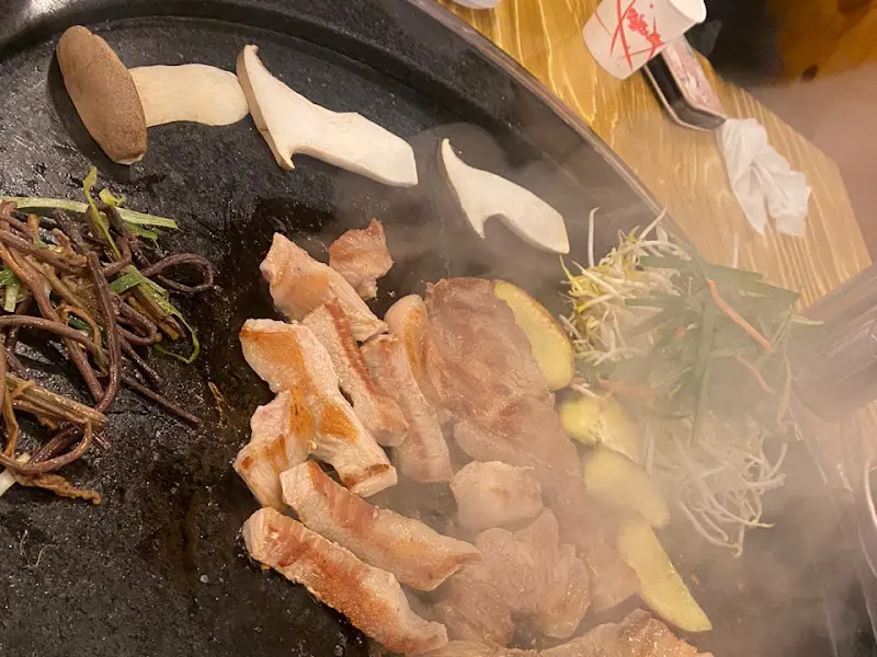 돌판에 구워지고 있는 삼겹살과 채소들