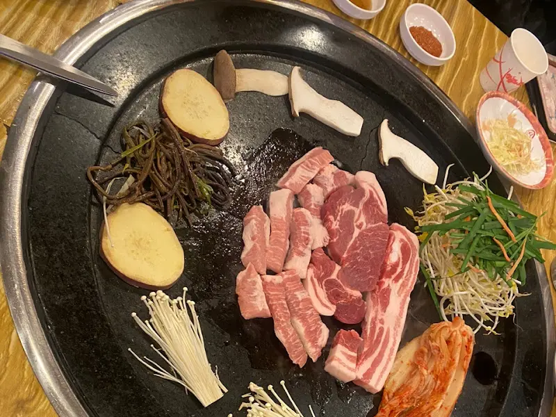 돌판에 구워지고 있는 삼겹살과 채소들