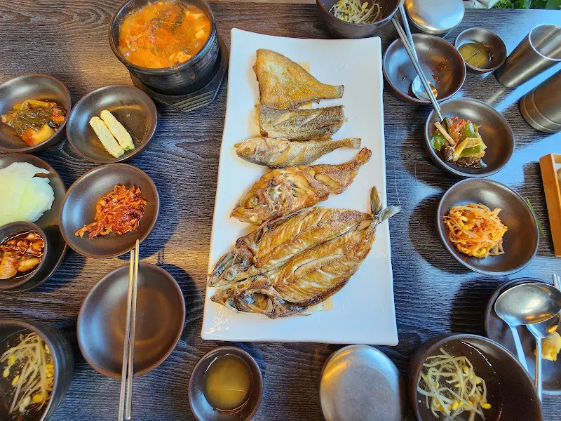 모듬 생선구이와 김치찌개가 함께 놓인 테이블 전경