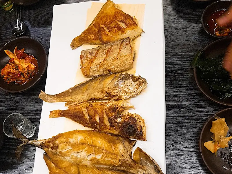 다양한 종류의 구운 생선들이 담긴 접시