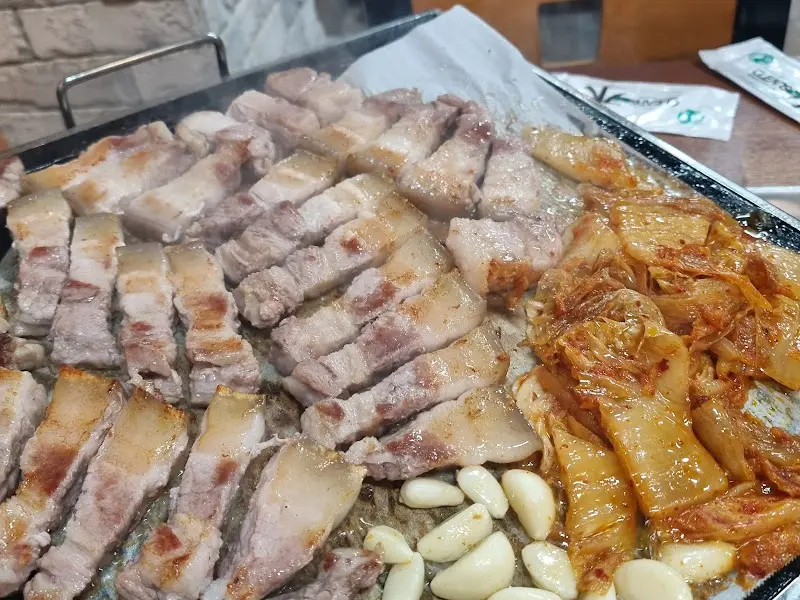 잘 구워진 오겹살과 김치, 마늘의 모습