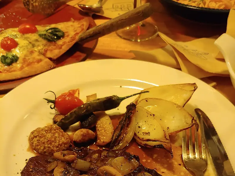 스테이크, 피자, 파스타가 놓인 테이블