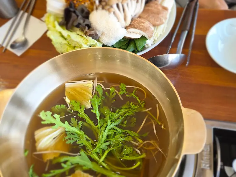 테이블 위에 놓인 버섯 샤브샤브 재료와 육수 냄비