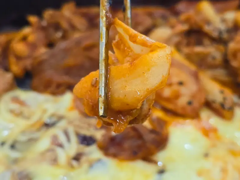 닭갈비와 떡을 함께 집어 올린 모습