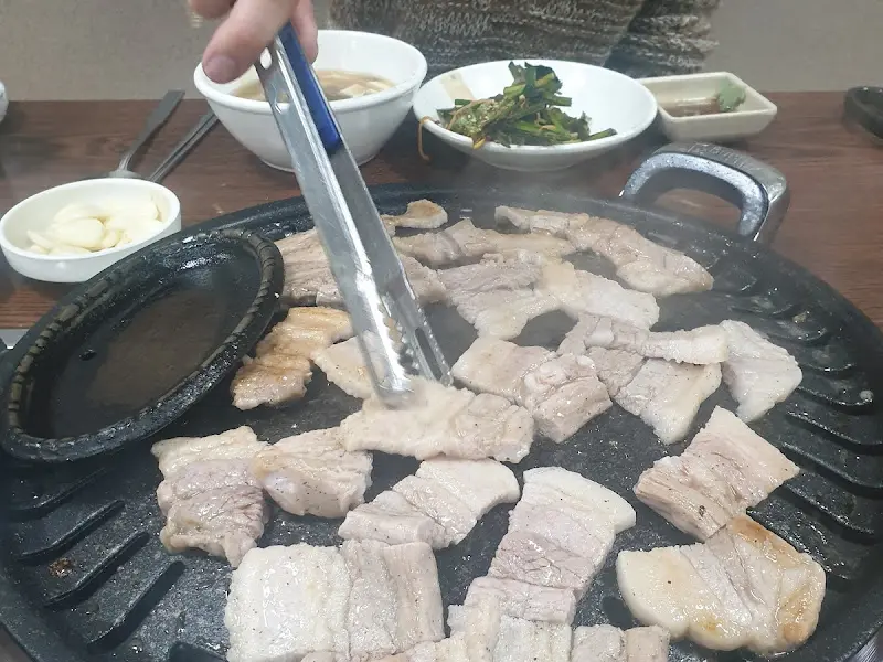 간장 소스에 담긴 삼겹살을 굽는 모습