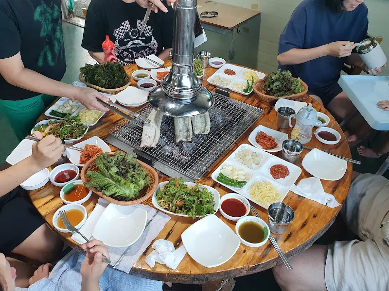 테이블 가득 차려진 장어구이와 밑반찬들