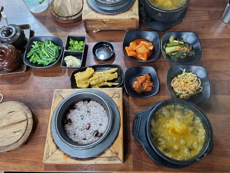 다양한 반찬과 추어탕, 돌솥밥이 차려진 푸짐한 상