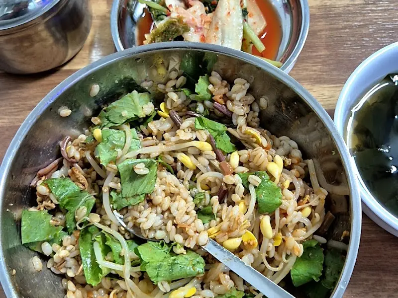 보리밥과 김치, 국물이 함께 놓인 사진