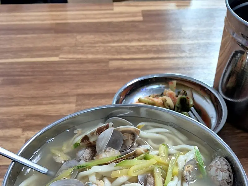 바지락 칼국수와 김치가 놓인 테이블 전경