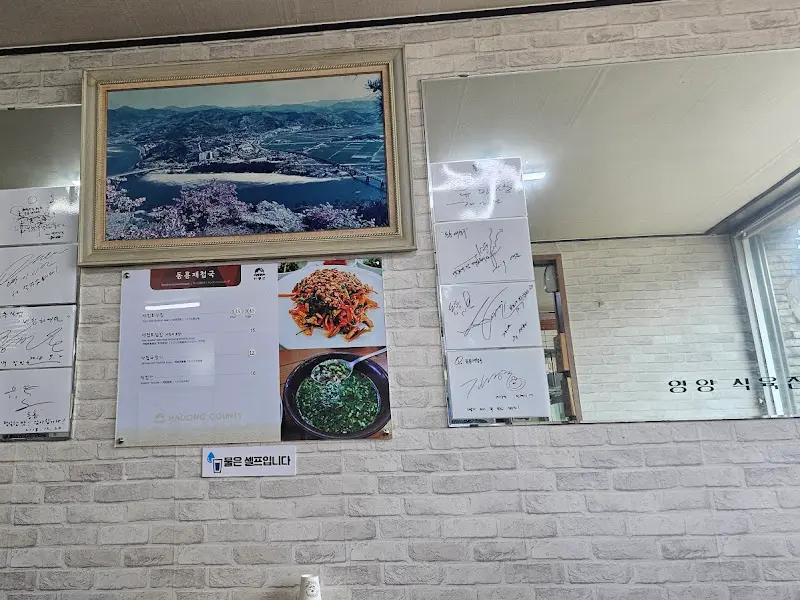 메뉴 안내와 방문객들의 싸인이 가득한 벽면