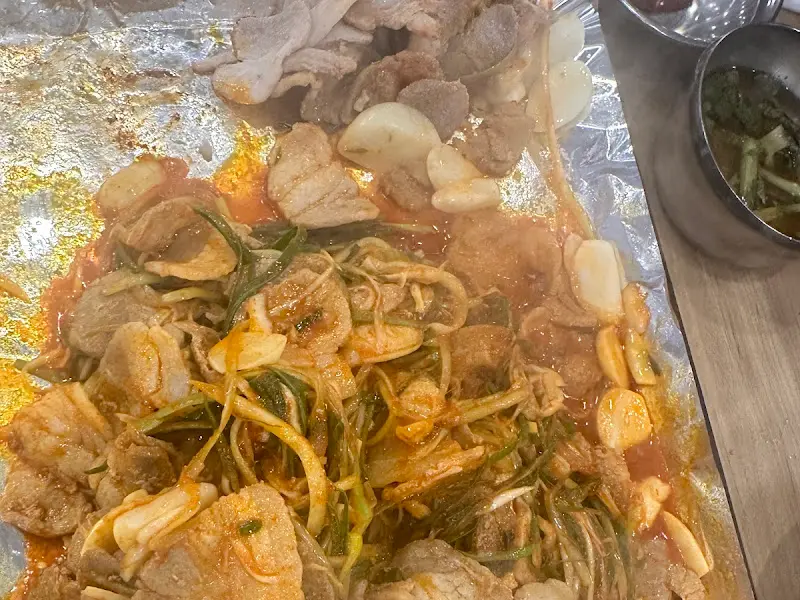 삼겹살, 파절이, 마늘을 함께 볶는 모습