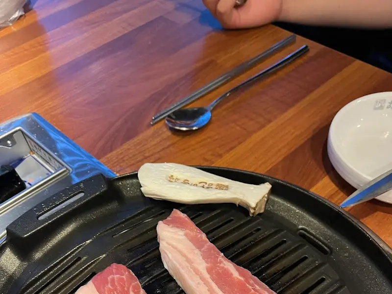 불판 위에 올려진 고기와 버섯