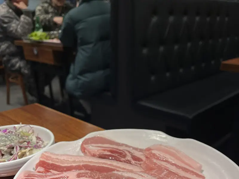 불판 위에 구워진 고기를 먹기 좋게 자르는 모습