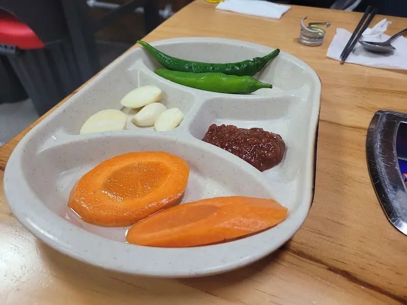 기본 반찬으로 나오는 채소 스틱과 쌈장, 고추, 마늘