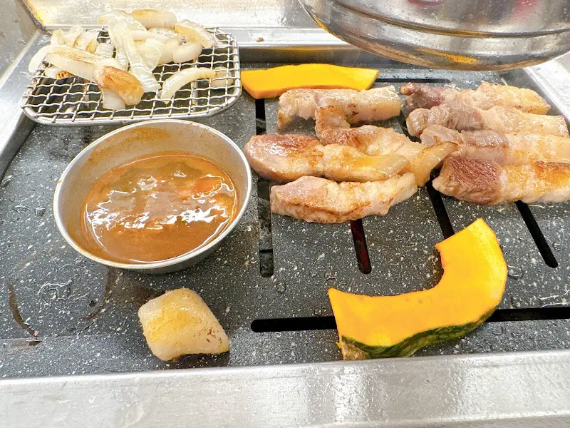 불판 위의 돼지고기와 김치찌개