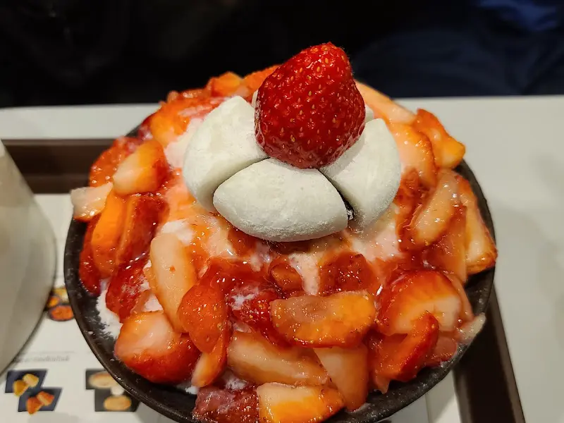 딸기 빙수의 클로즈업 사진. 맨 위에는 커다란 딸기와 찹쌀떡이 올려져 있다.