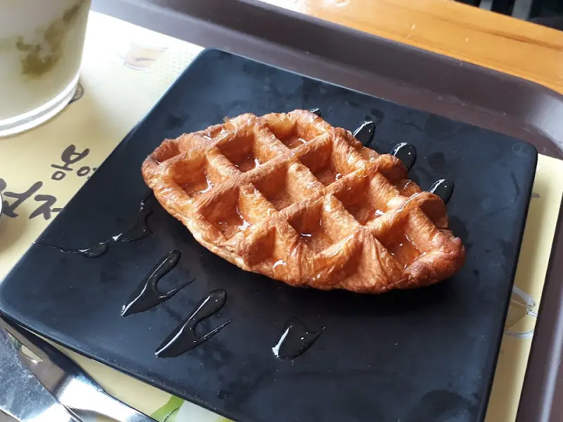 검은 접시에 놓인 먹음직스러운 와플