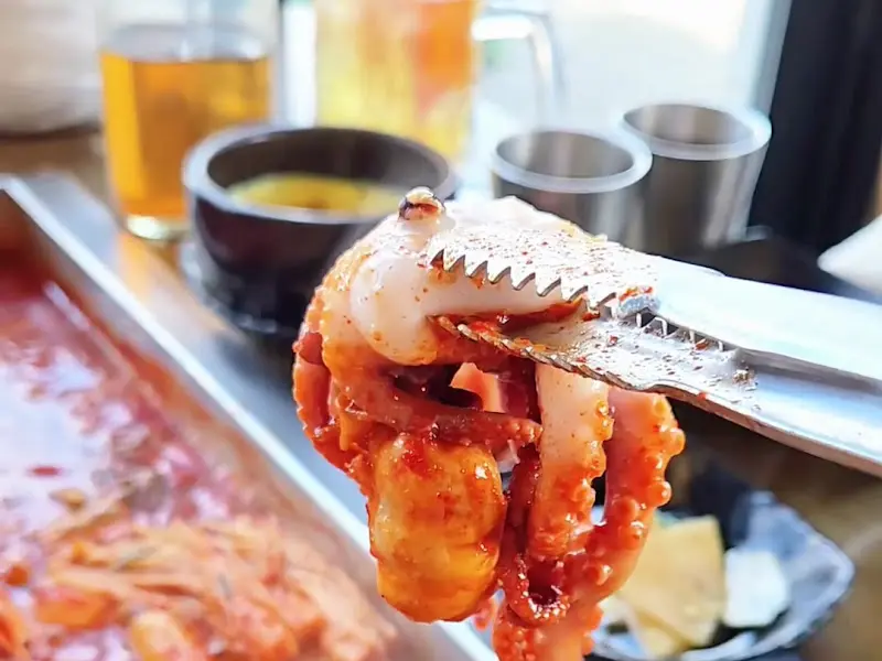 집게로 갈치조림을 들어올리는 모습