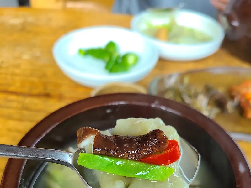 수제비와 채소를 함께 떠먹는 모습