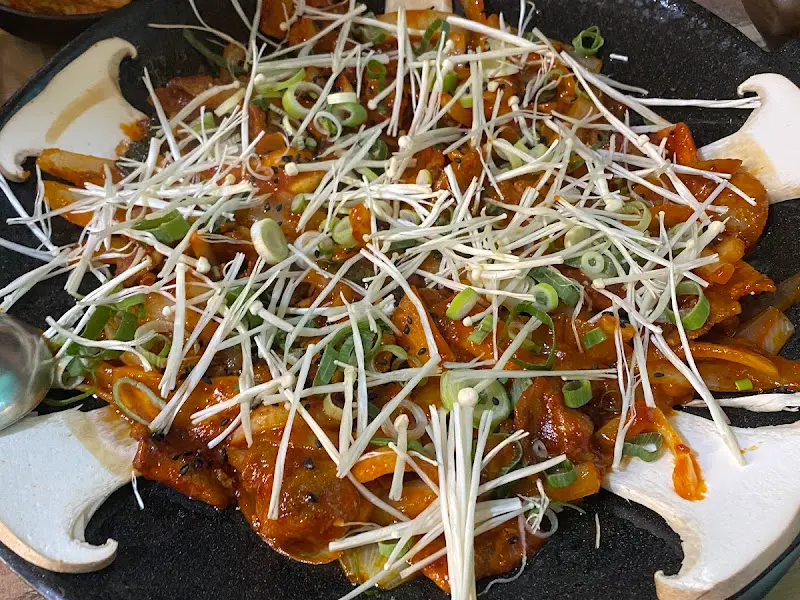 팽이버섯이 듬뿍 올라간 제육철판의 모습