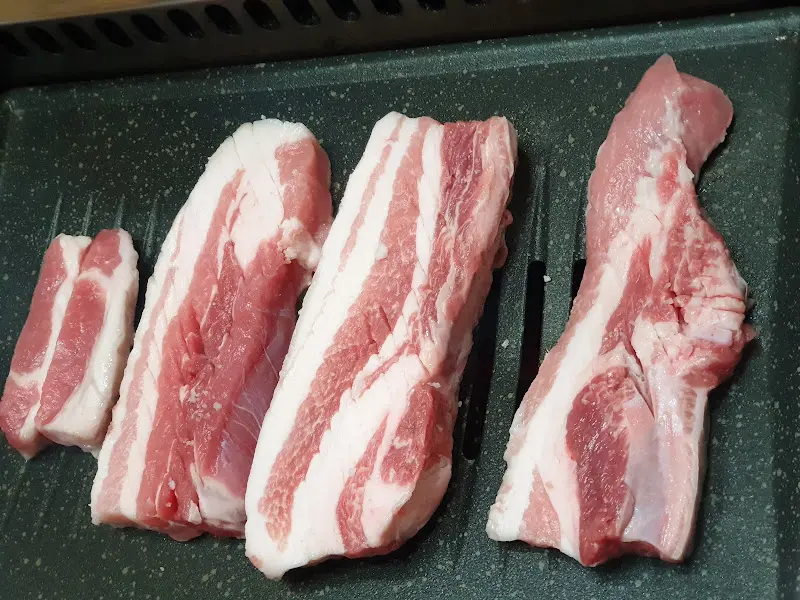 불판 위 노릇하게 구워진 삼겹살