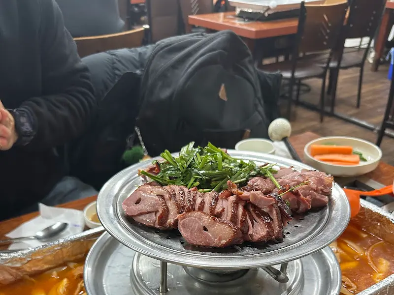 윤기가 흐르는 훈제오리와 신선한 부추의 조화