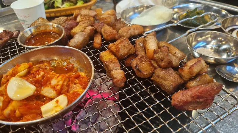 잘 구워진 삼겹살과 김치가 함께 놓여있는 모습