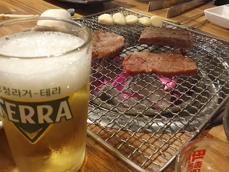 숯불 위에서 맛있게 구워지고 있는 소고기와 마늘의 모습