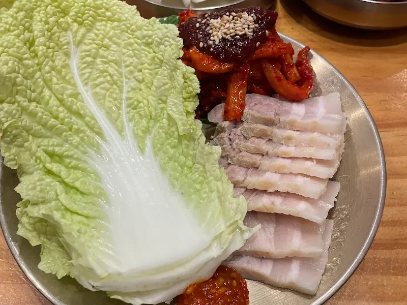 윤기가 흐르는 보쌈과 신선한 배추, 곁들임 무김치의 환상적인 조화