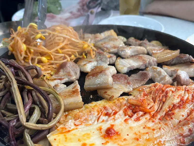 불판 위 삼겹살과 밑반찬