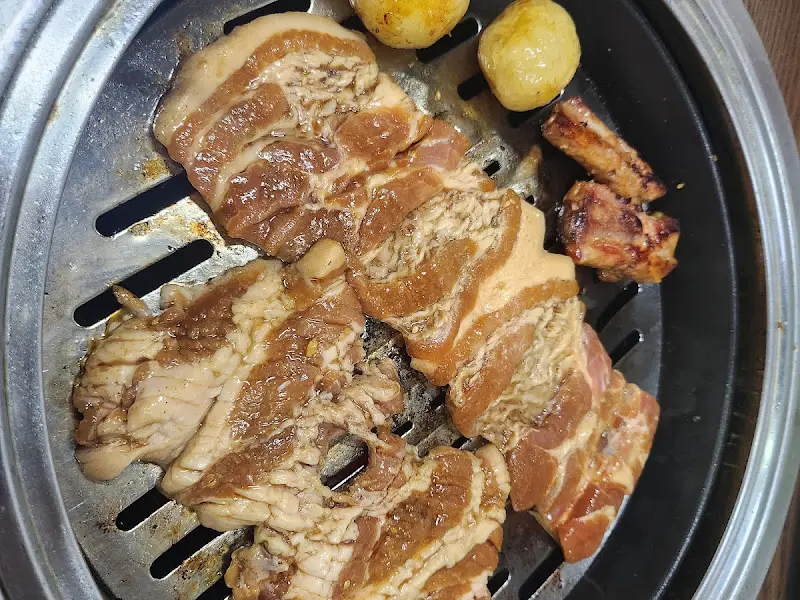 숯불 위에서 익어가는 돼지갈비와 감자