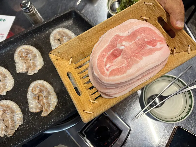 나무 도마 위에 가지런히 놓인 냉삼겹살