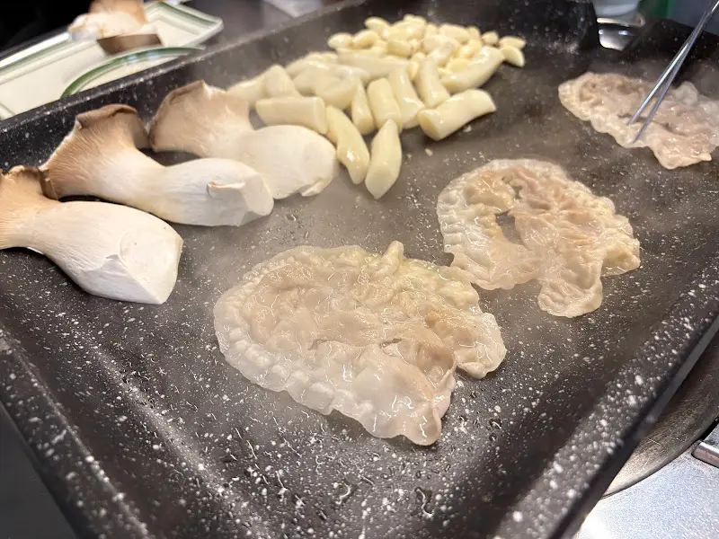 불판 위에서 구워지는 마늘, 떡, 버섯