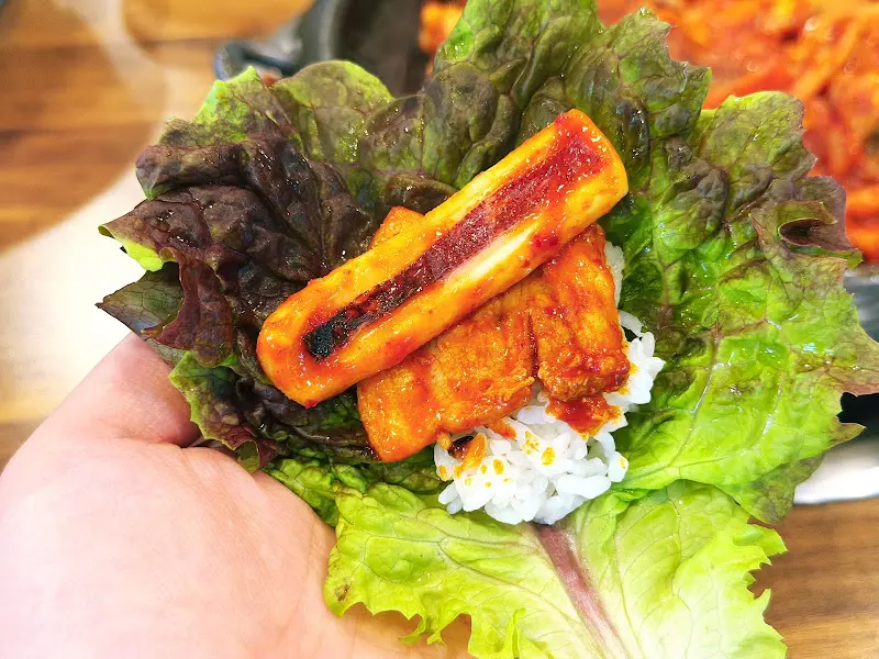 오삼불고기를 쌈에 싸서 먹는 모습