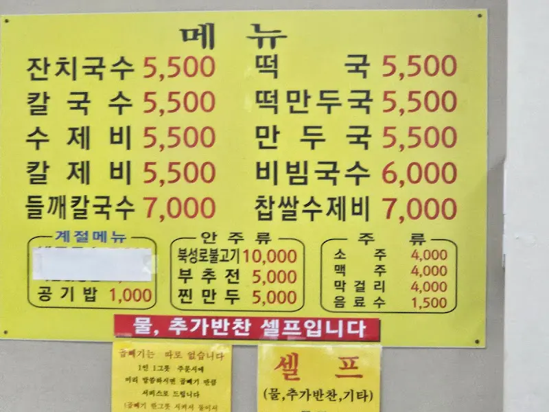 식당 메뉴판 사진. 잔치국수, 칼국수, 수제비, 비빔국수 등의 메뉴와 가격이 적혀 있다.