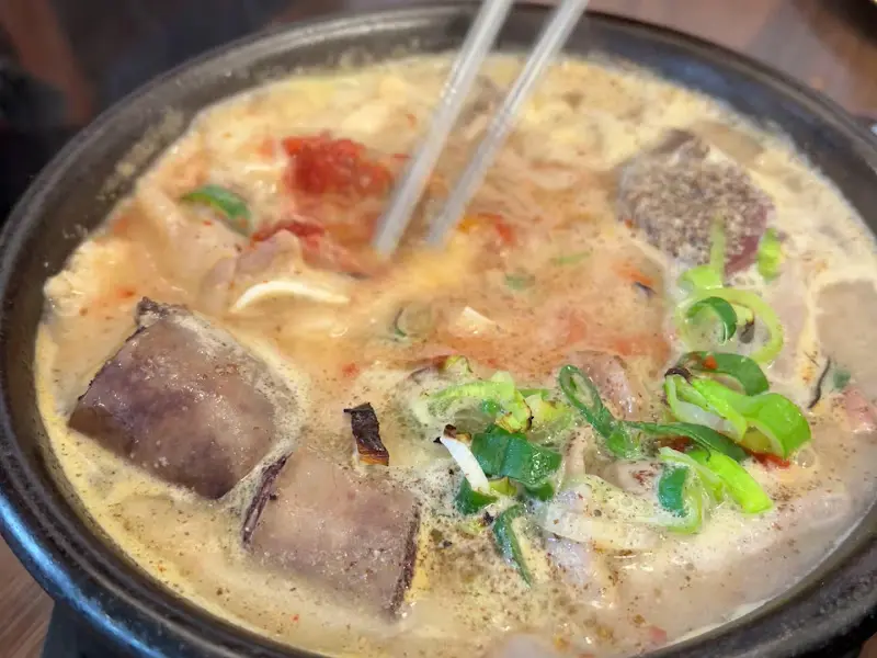 젓가락으로 암뽕순대를 집어 올리는 모습