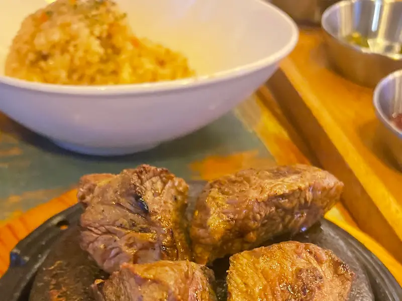 돌판 위에 스테이크, 볶음밥, 그리고 푸짐한 곁들임 메뉴