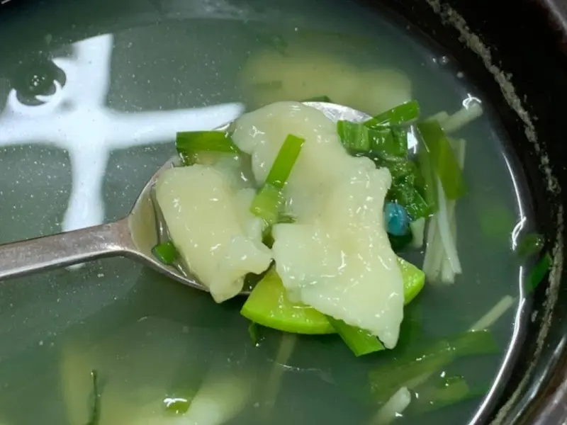 수저 위에 올려진 다슬기와 수제비