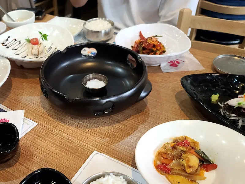 테이블 위에 놓인 다양한 반찬과 석갈비를 담을 수 있는 공간이 있는 테이블 세팅