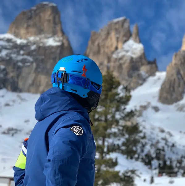 스키장에서 푸른색 스키복을 입은 사람의 뒷모습