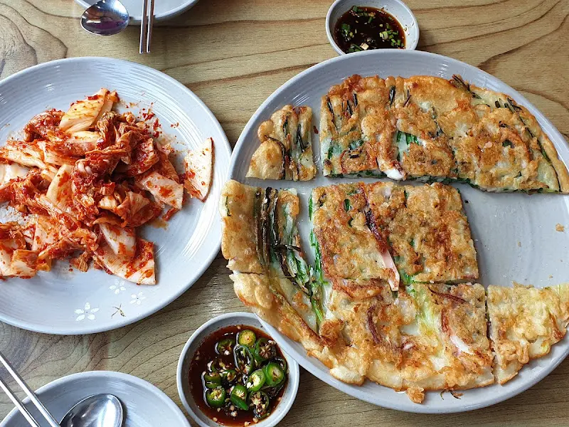 칼국수, 김치, 파전이 놓인 테이블 전경