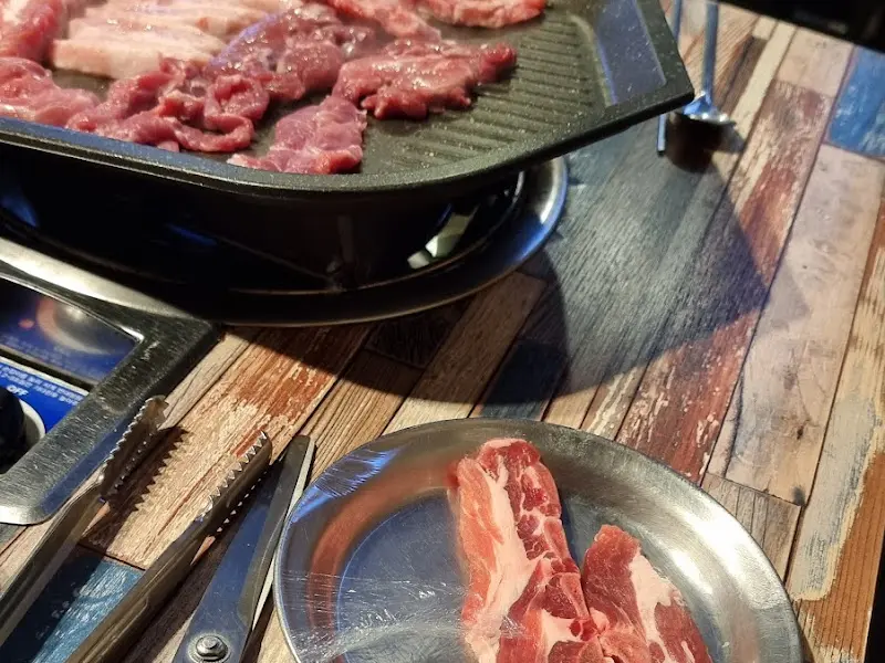 불판 위에서 맛있게 익어가는 삼겹살과 목살