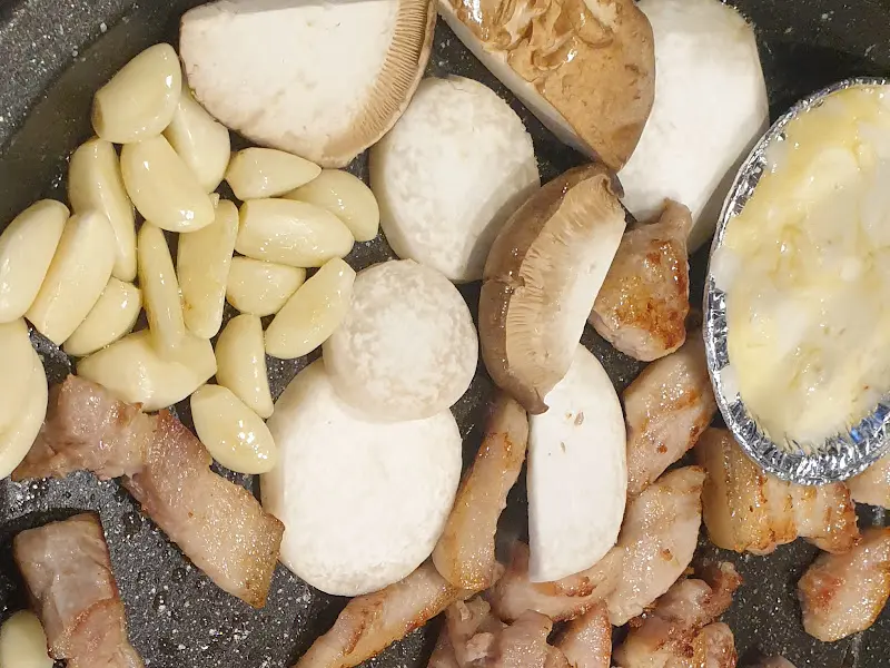 돼지 기름에 구워진 김치, 버섯, 마늘