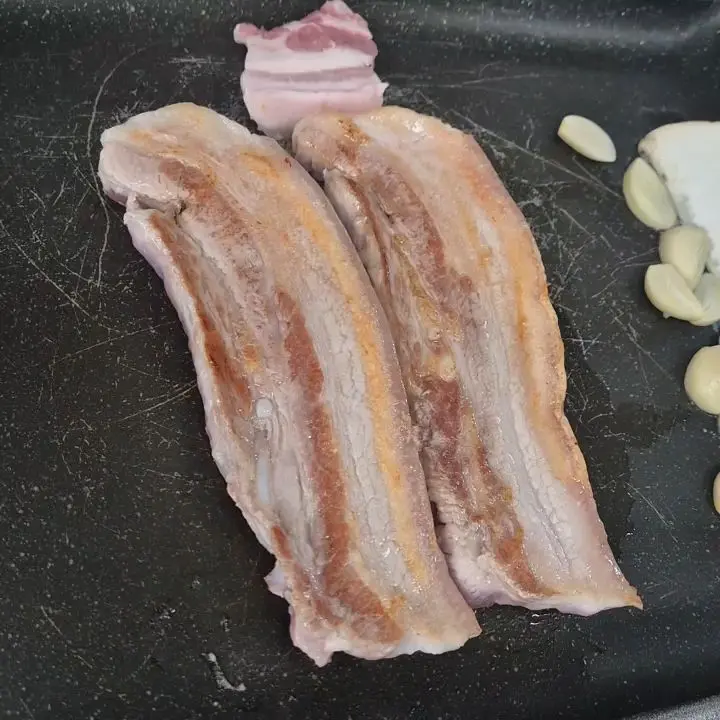 불판 위에서 노릇하게 구워지는 오겹살