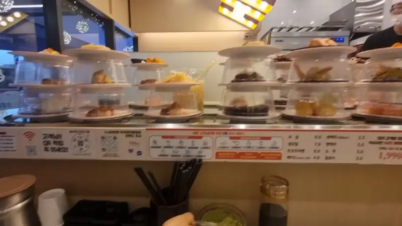 회전 레일 위를 쉴 새 없이 오가는 초밥들