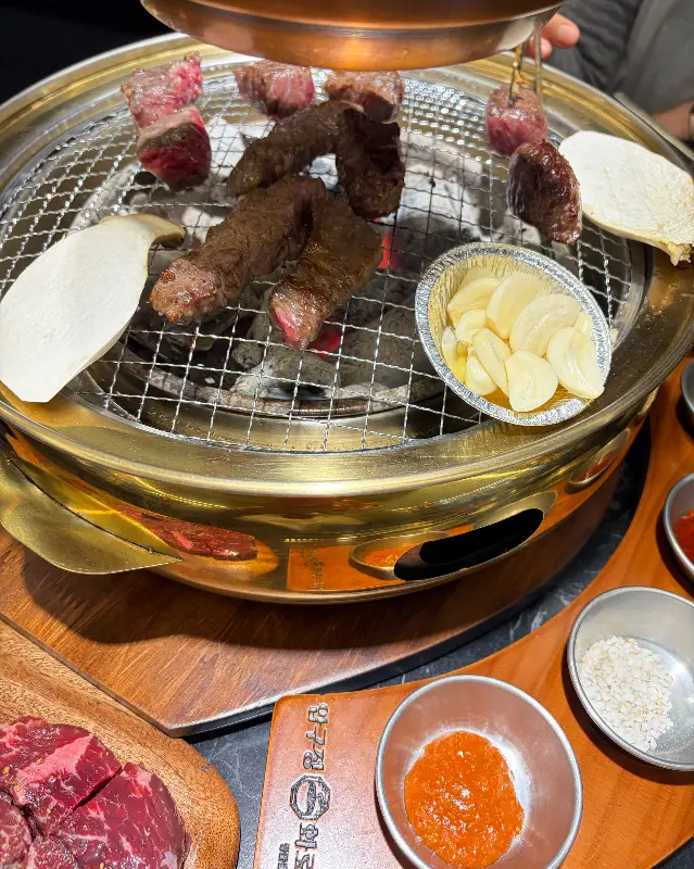 화로 위에서 구워지는 소고기와 버섯, 마늘